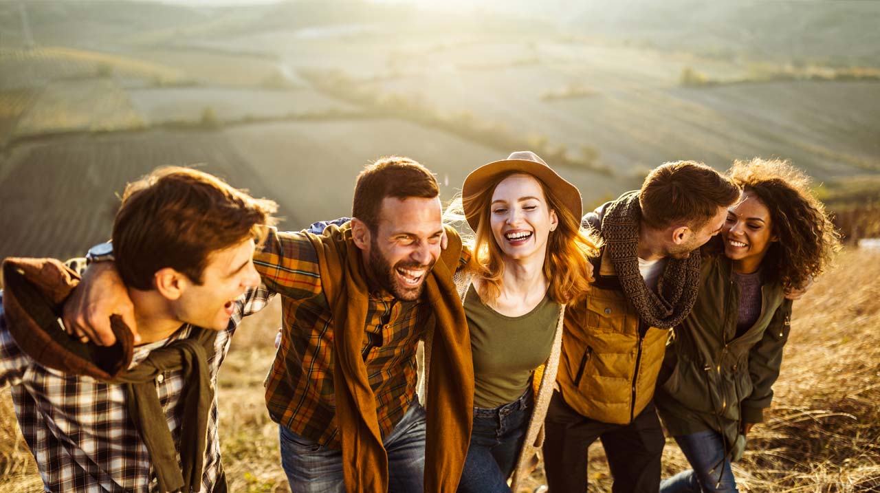 Gruppo di amici fa un pic nic sul prato. 