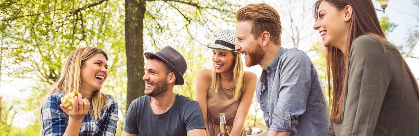 Gruppo di amici si diverte all'ombra degli alberi.