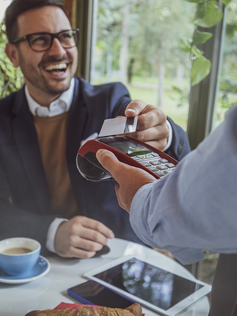 Ragazzo paga con la sua carta contactless in un caffè.