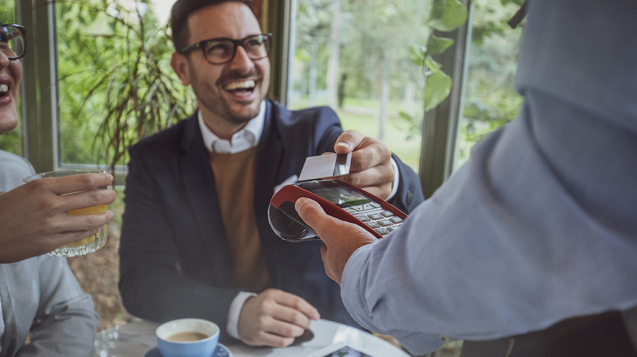 Ragazzo paga con la sua carta contactless in un caffè.