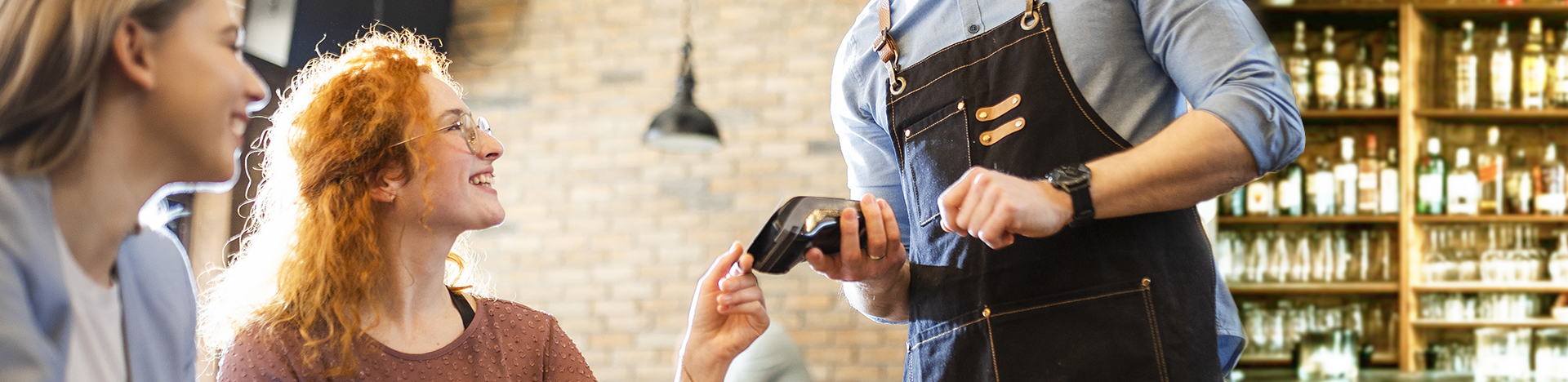 Coppia di amiche paga con la carta contactless in un ristorante