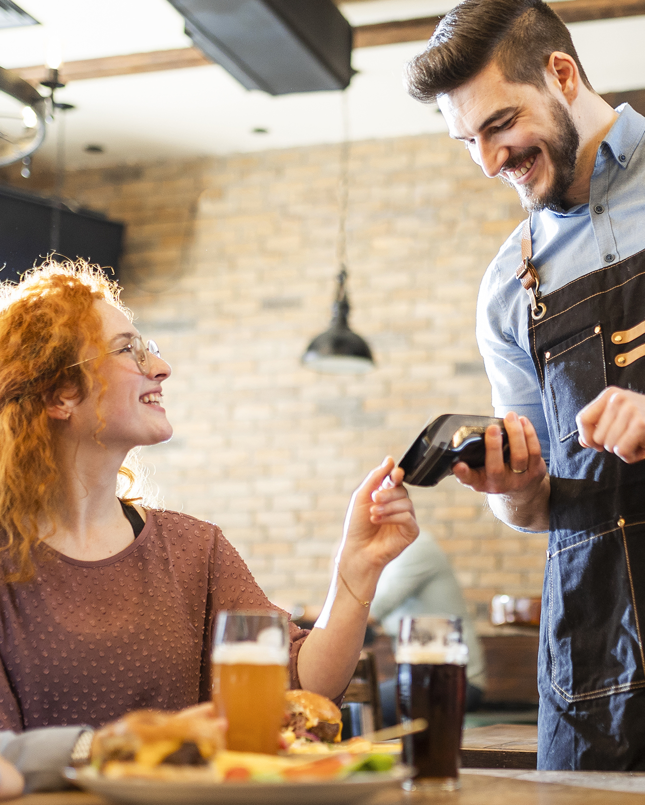 Coppia di amiche paga con la carta contactless in un ristorante