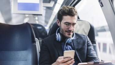 Giovane in abito opera in modibilità con tablet e smartphone