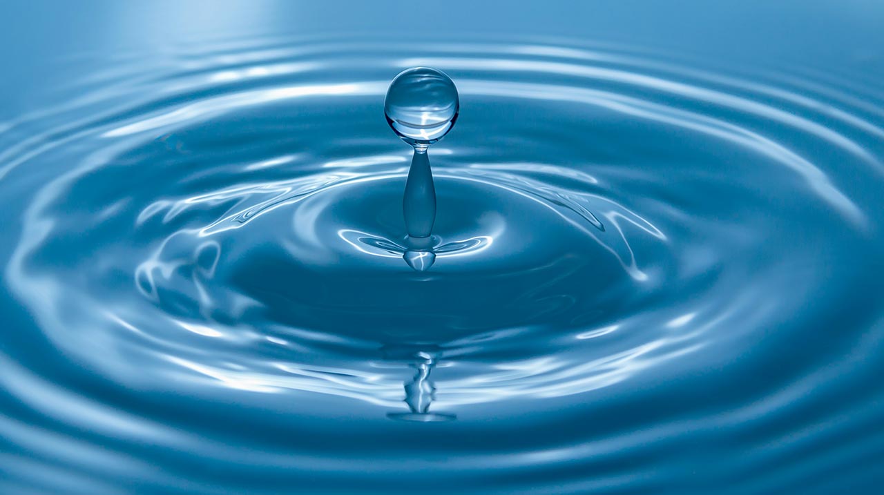 Goccia che cade nell'acqua e crea dei cerchi circolari.