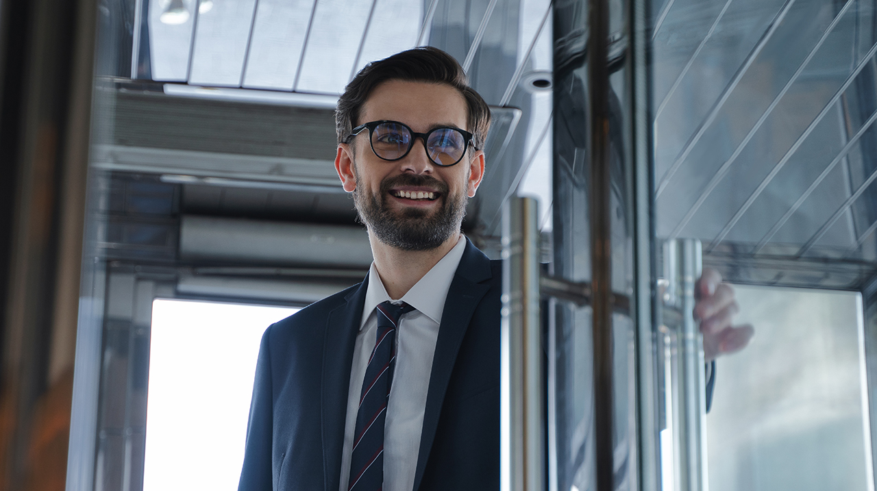 Giovane uomo d'affari sorridente entra in un building