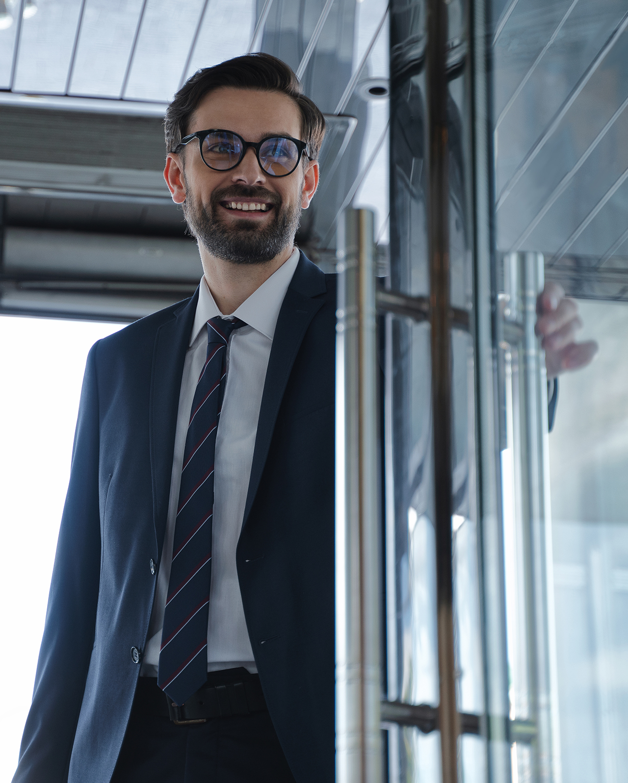 Uomo d'affari seduto al bar consulta il tablet e accede a contenuti multimediali con cuffie wireless