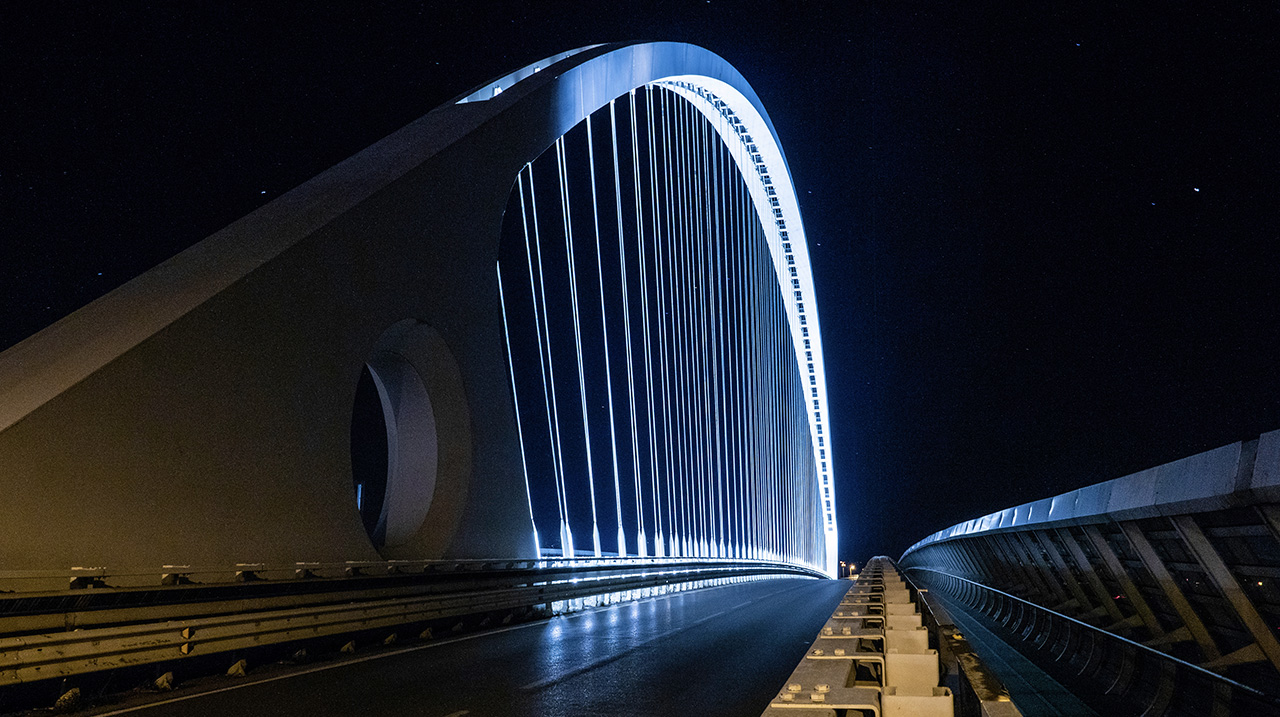 Un ponte illunimato con lo sfondo di un cielo stellato