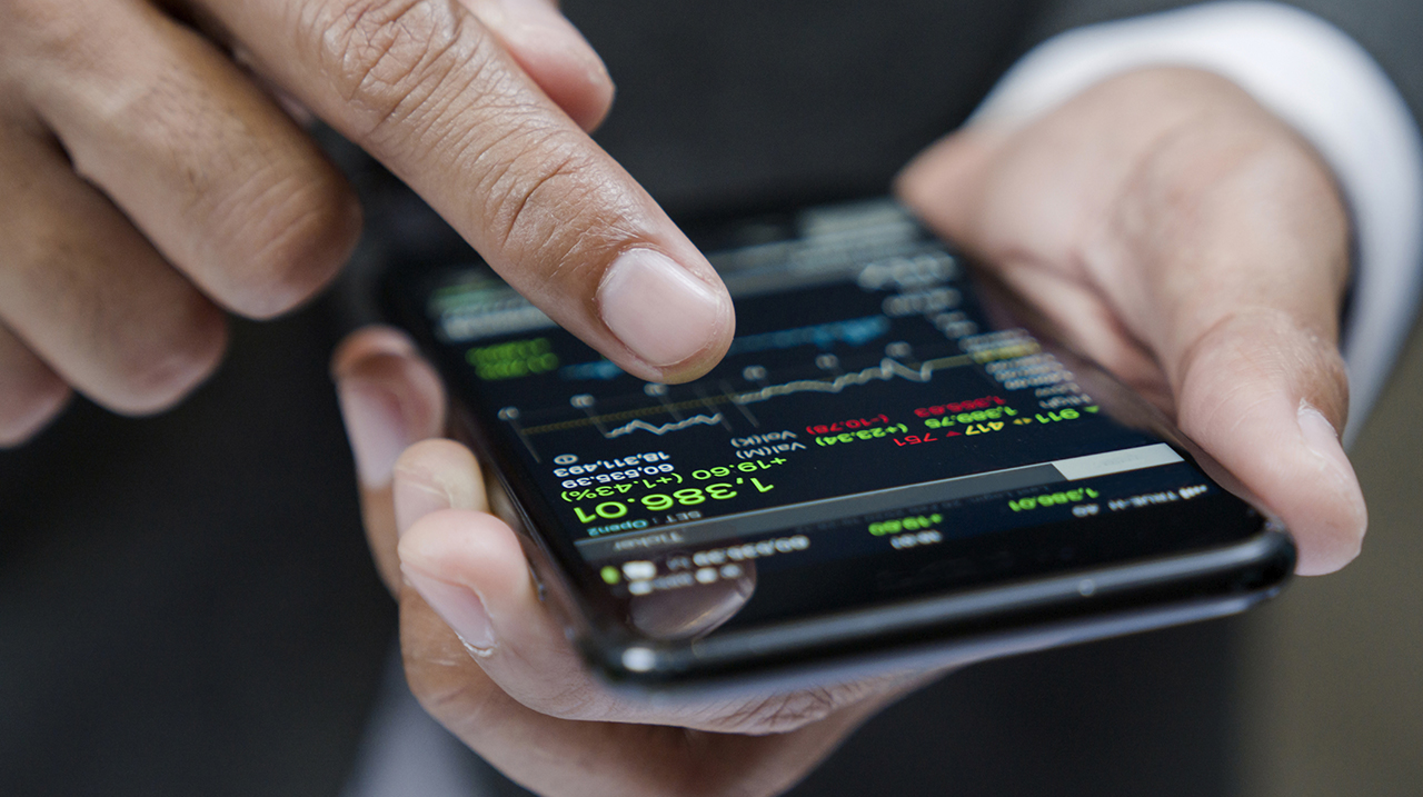 Businessman using a mobile phone to check stock market data