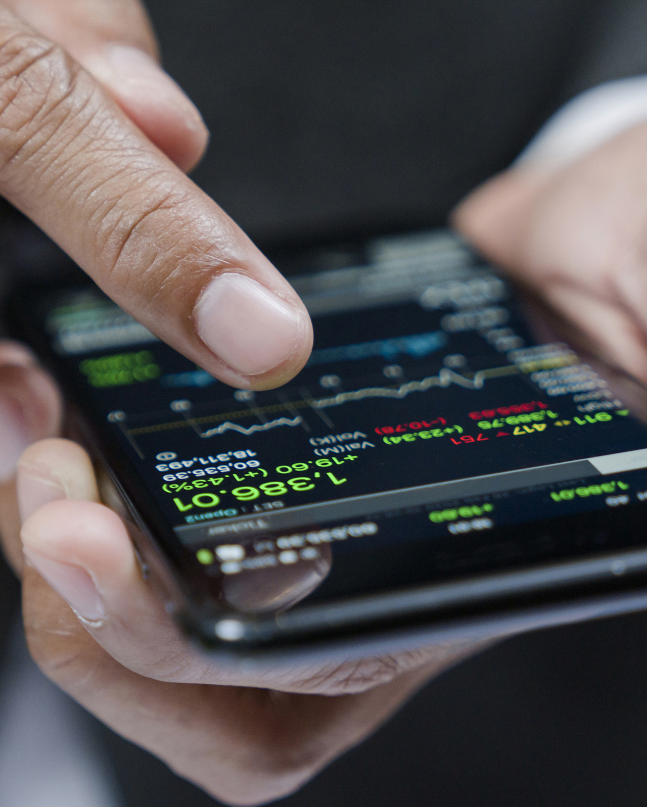 Businessman using a mobile phone to check stock market data